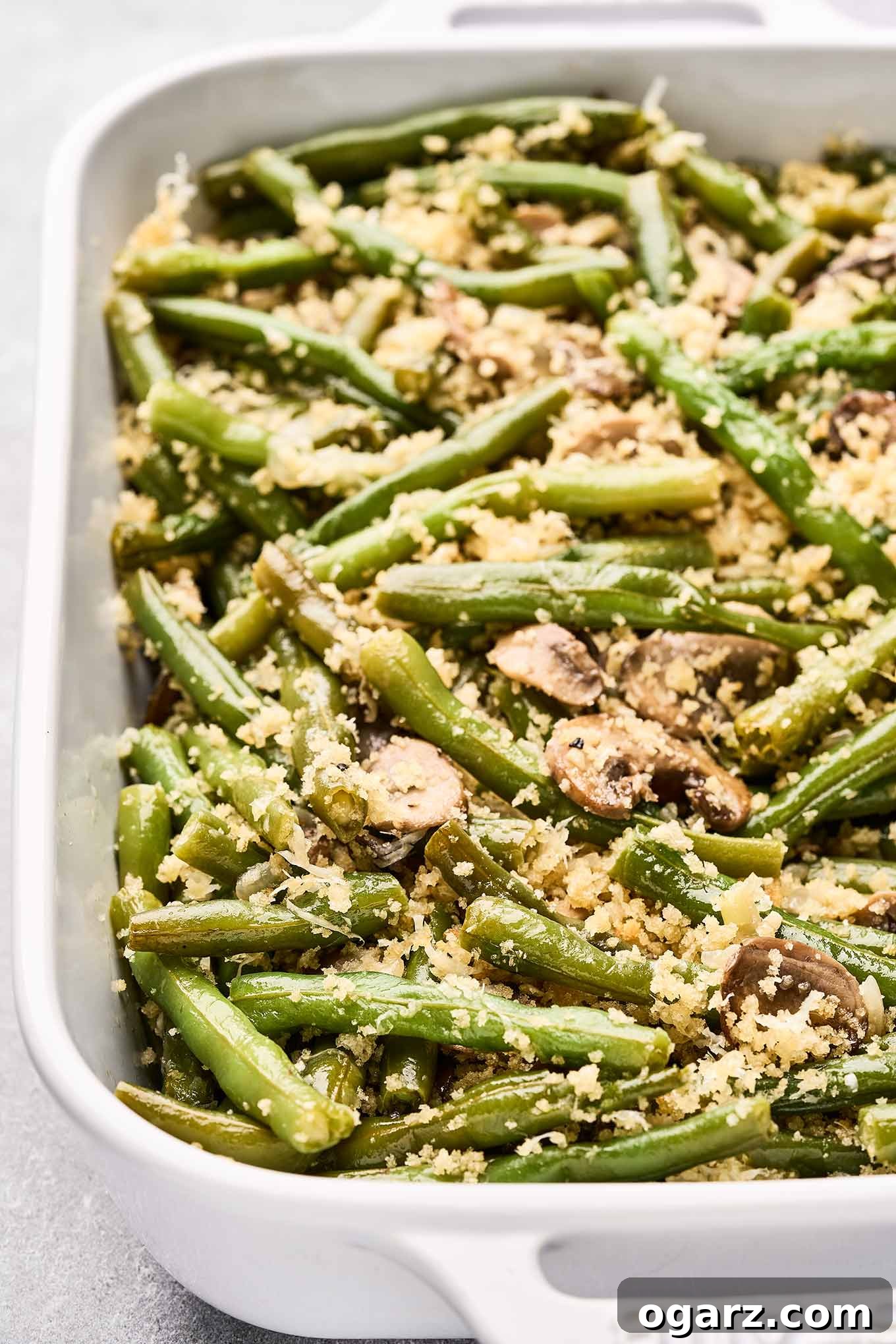 Golden Crumb Green Bean and Mushroom Medley 4 A close-up view of the baked green beans and mushrooms with a perfectly golden and crispy panko and Parmesan crumb topping, showing the tender beans underneath.