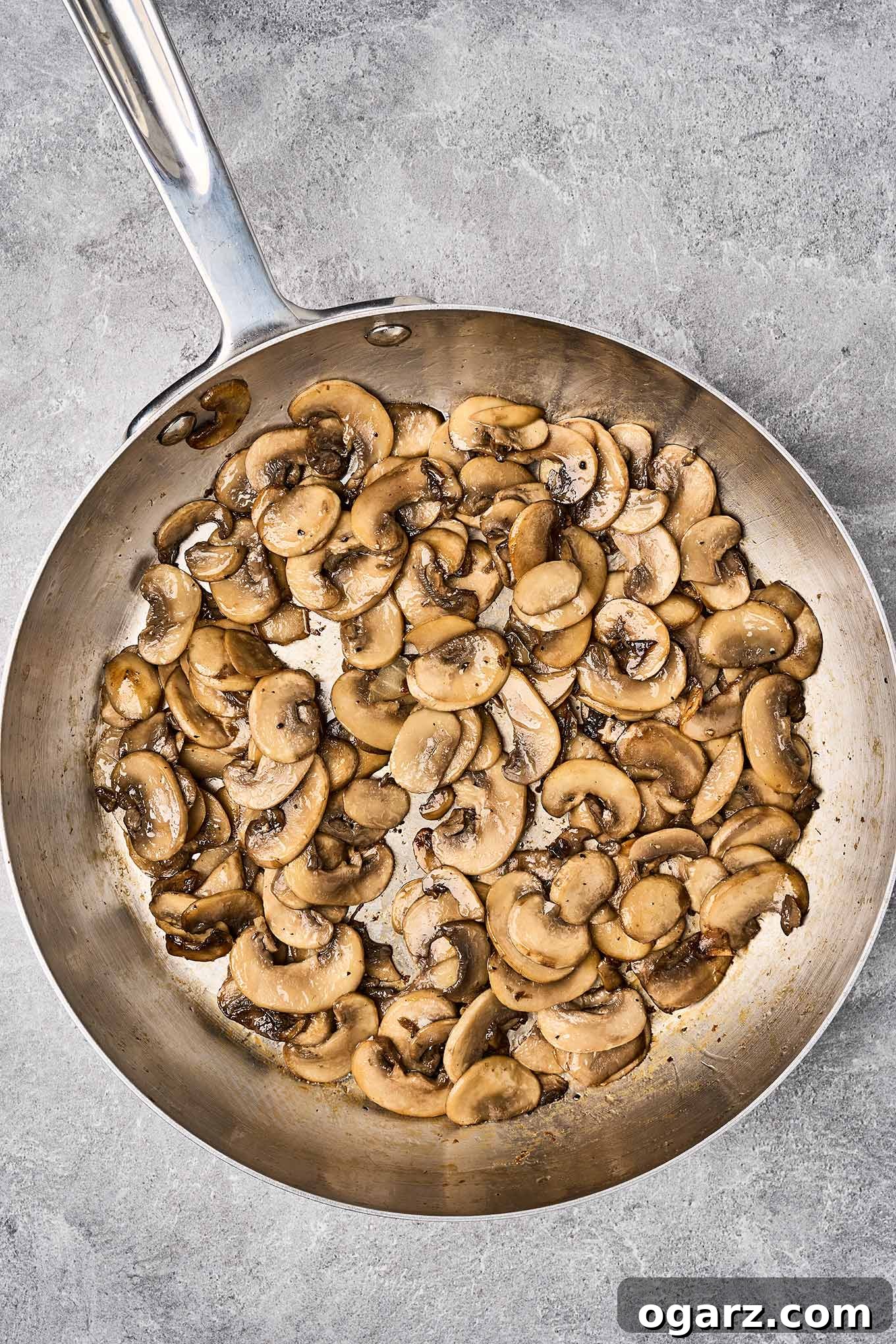 Golden Crumb Green Bean and Mushroom Medley 6 Sautéed cremini mushrooms perfectly browned in a frying pan, prepared for the baked green beans and mushrooms with Parmesan and panko crumb topping.