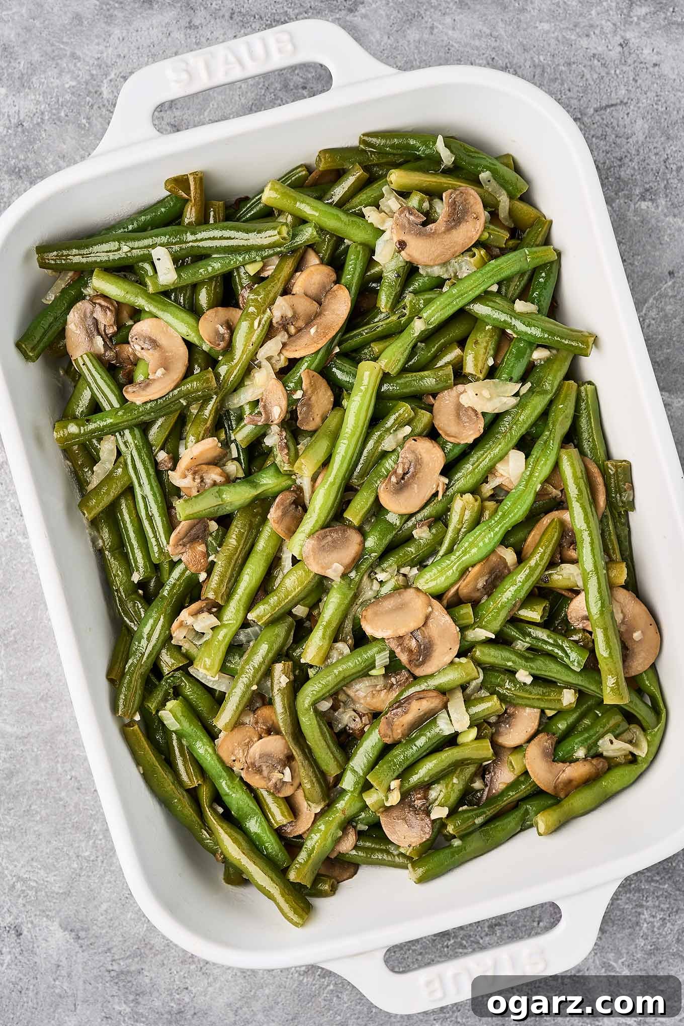 Golden Crumb Green Bean and Mushroom Medley 7 Fresh green beans and sautéed mushrooms arranged in an oblong casserole dish, ready to be topped with the panko-Parmesan mixture and baked.