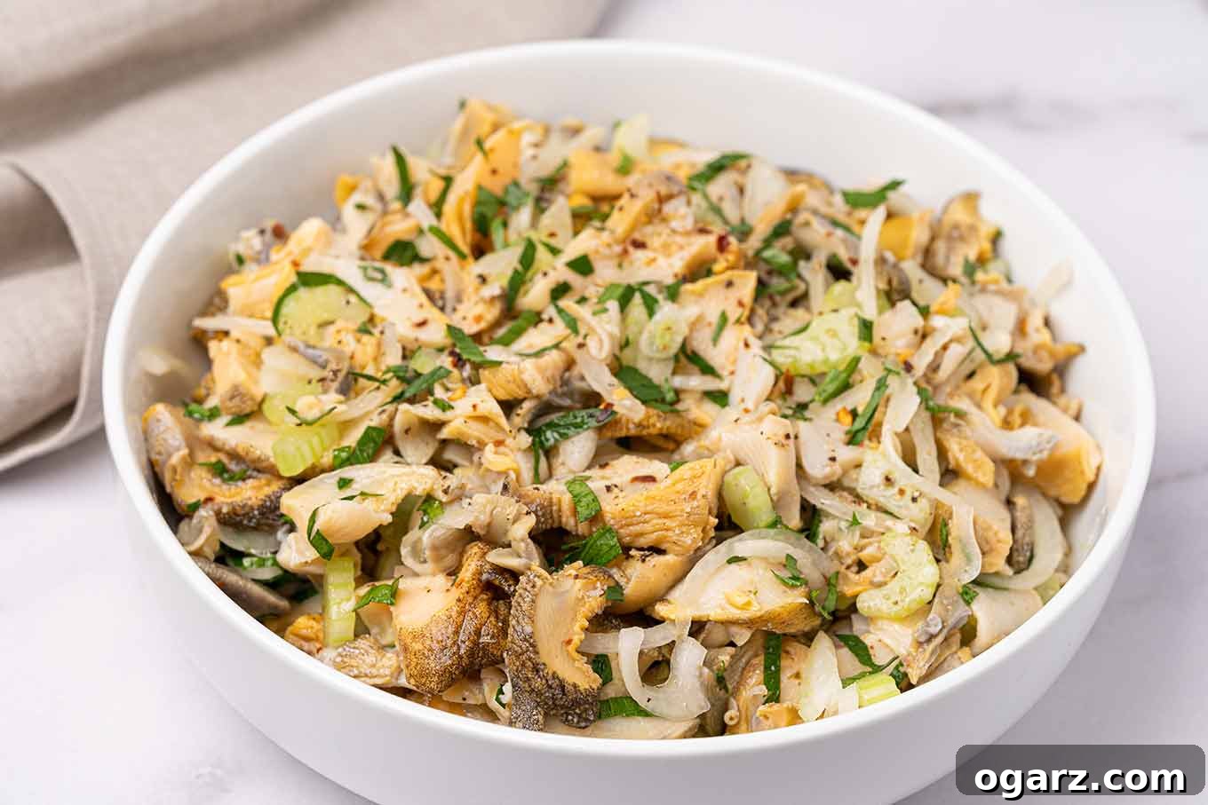 Italian-style snail salad with scungilli, celery, onion, parsley, and a kick of red pepper flakes.