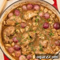 Slow-Braised Red Wine Chicken Thighs 3 A cast iron pan filled with boneless chicken thighs braised in red wine with bacon, thyme, mushrooms, and pearl onions.