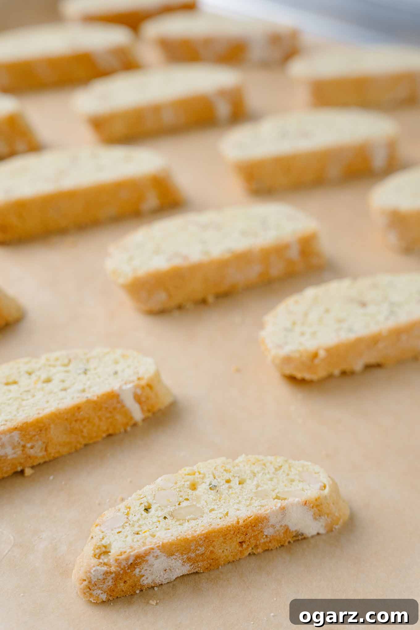 Golden Buttery Orange Biscotti 5 A close up photo of sliced orange biscotti on a baking sheet ready for the second baking.