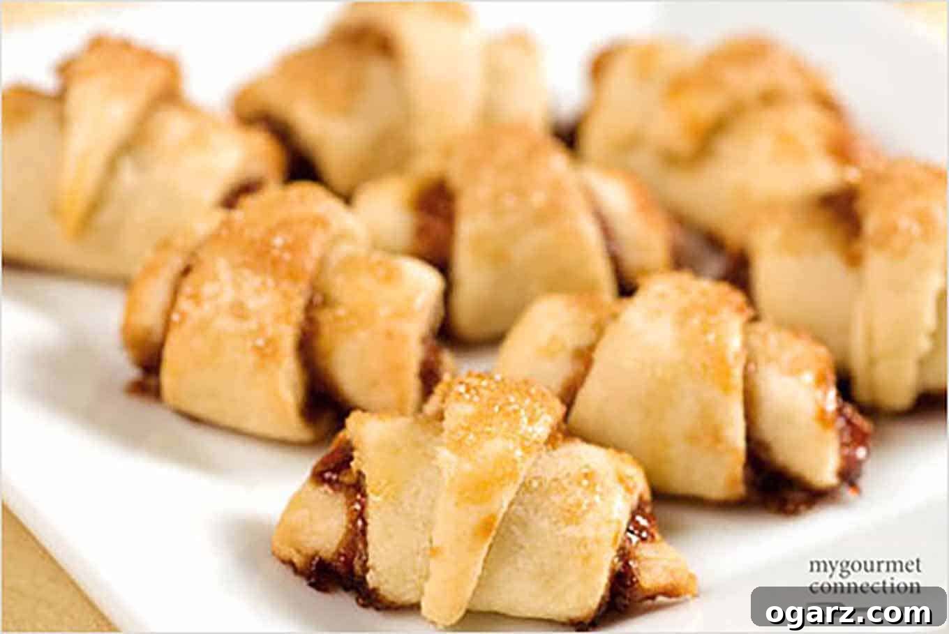 Delicious Raspberry Rugelach with a flaky cream cheese dough, topped with coarse sugar.