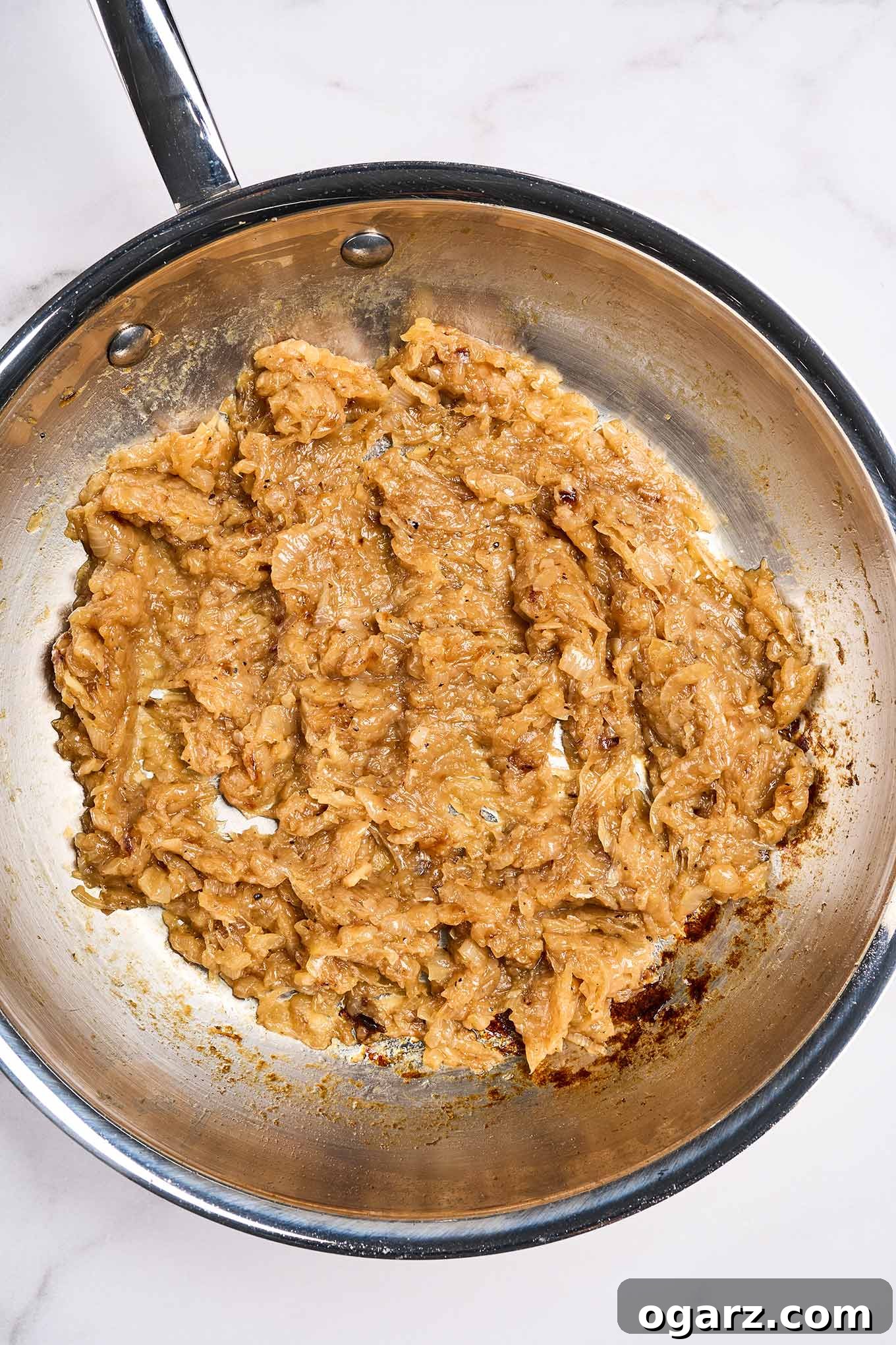 Mastering Caramelized Onions From Pan to Perfection 5 Fully caramelized onions in a stainless skillet, cooked down to a spreadable, jam-like consistency after 45 to 50 minutes of cooking.