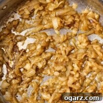 A stainless steel skillet filled with perfectly caramelized onions.