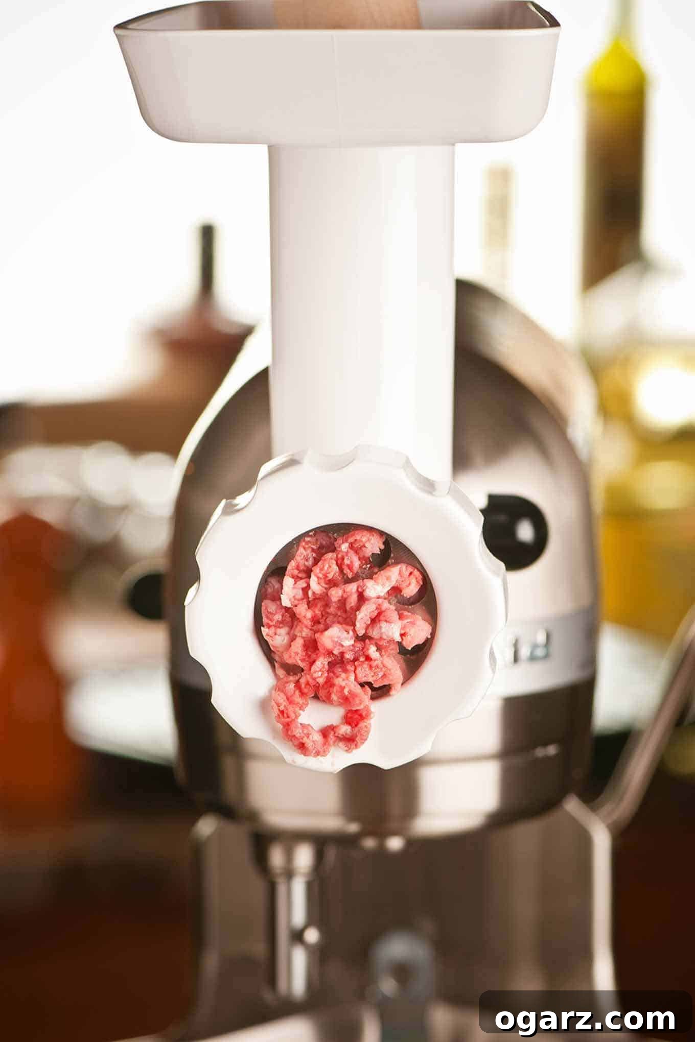 Master the Art of the Perfect Burger 3 An electric meat grinder actively processing beef into fresh ground meat, highlighting the initial step in crafting homemade burgers.