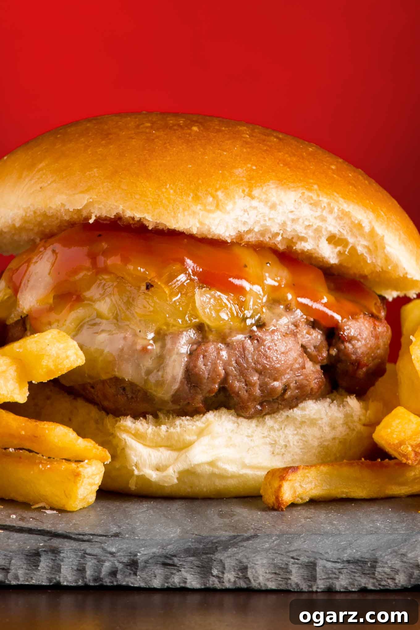 A juicy grilled burger topped with onions, Vermont cheddar cheese, and maple ketchup.