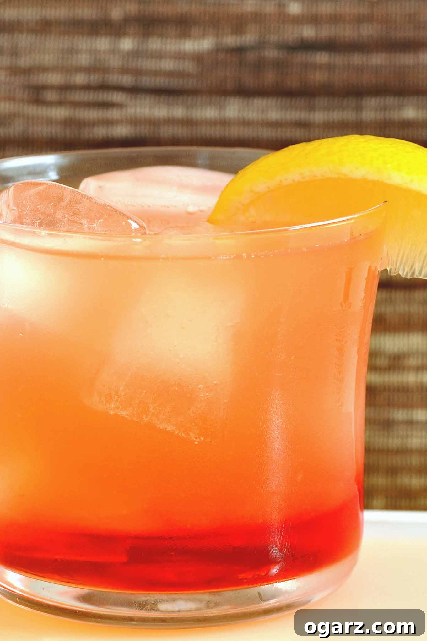 Riviera Sunset Spritz 2 A vibrant Campari-Limoncello Spritzer cocktail garnished with a fresh lemon slice, set against a bright background, perfect for a refreshing drink.