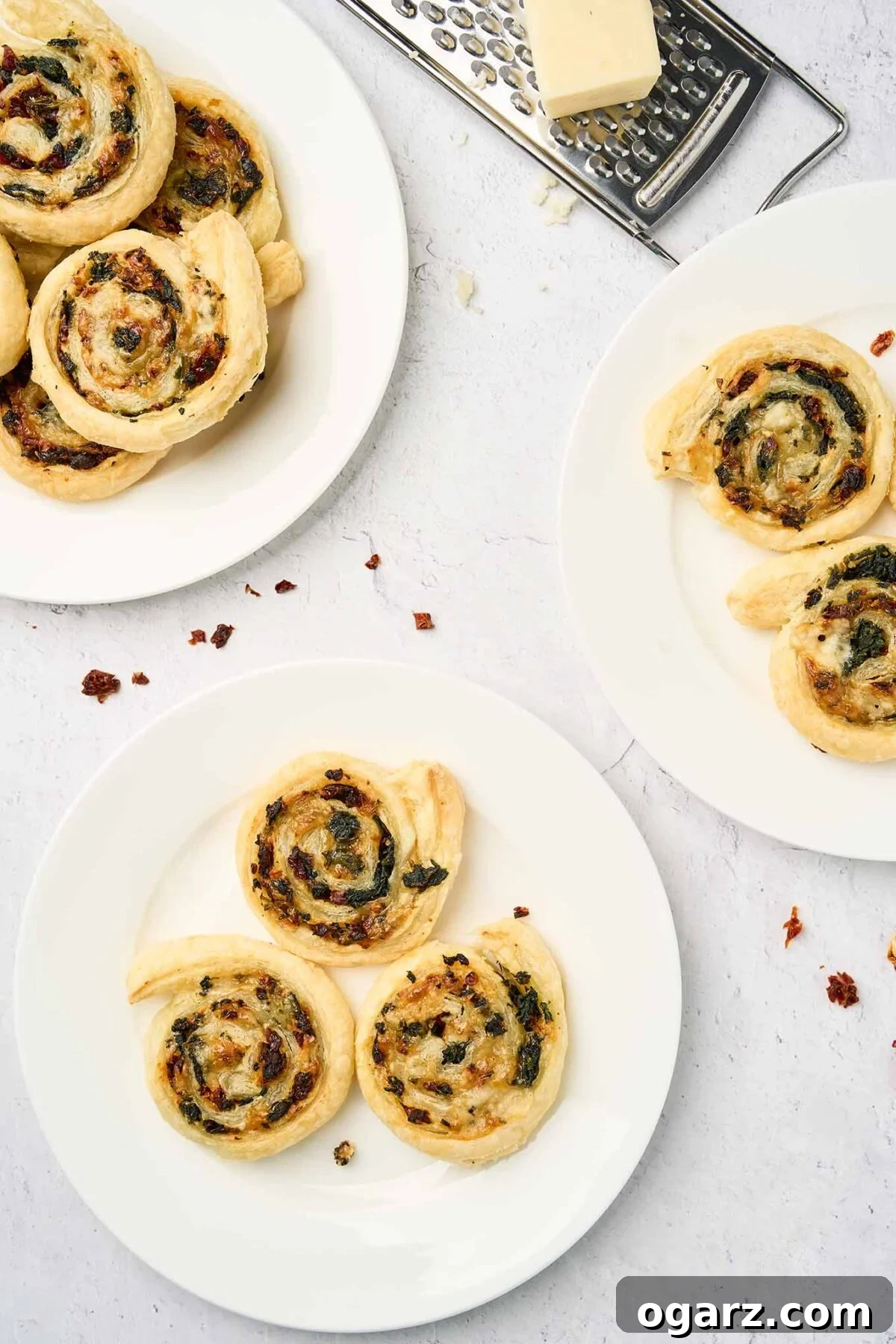 Savory Spinach Swirls 8 Plated spinach pinwheels made with puff pastry, spinach, sun-dried tomatoes, and cheese, shown from a top-down view.