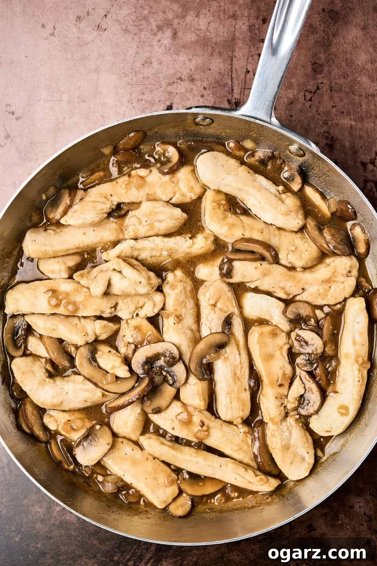 Savory Marsala Chicken and Tomato Pasta 5 A frying pan with chicken and mushrooms sautéed with garlic and onion in Marsala wine sauce.