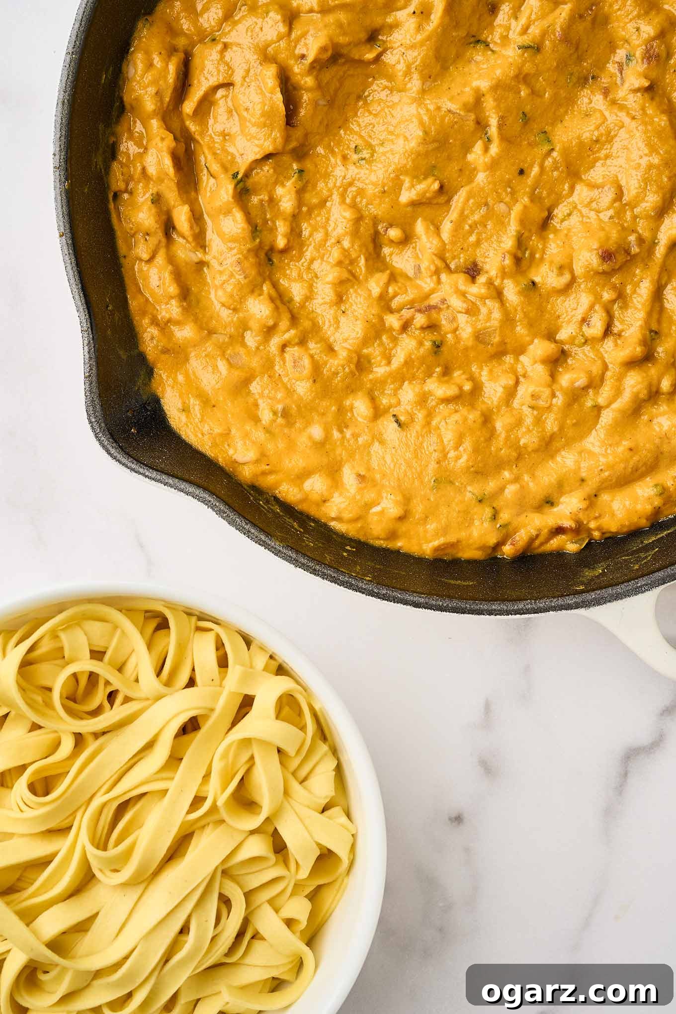Final step for preparing creamy pumpkin pasta, pumpkin mixture in a skillet ready to be combined with cooked fettuccine.