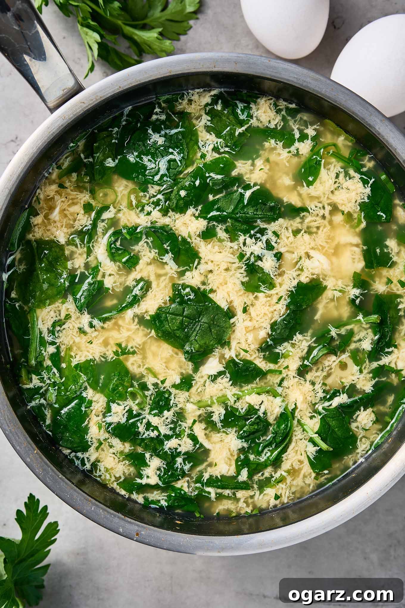 Spinach Pasta Stracciatella Soup 5 Fresh spinach wilting in a pot of stracciatella soup with egg ribbons and broth.