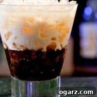 White Russian cocktail served over ice in a short glass, with layers of cream and coffee liqueur swirling together.
