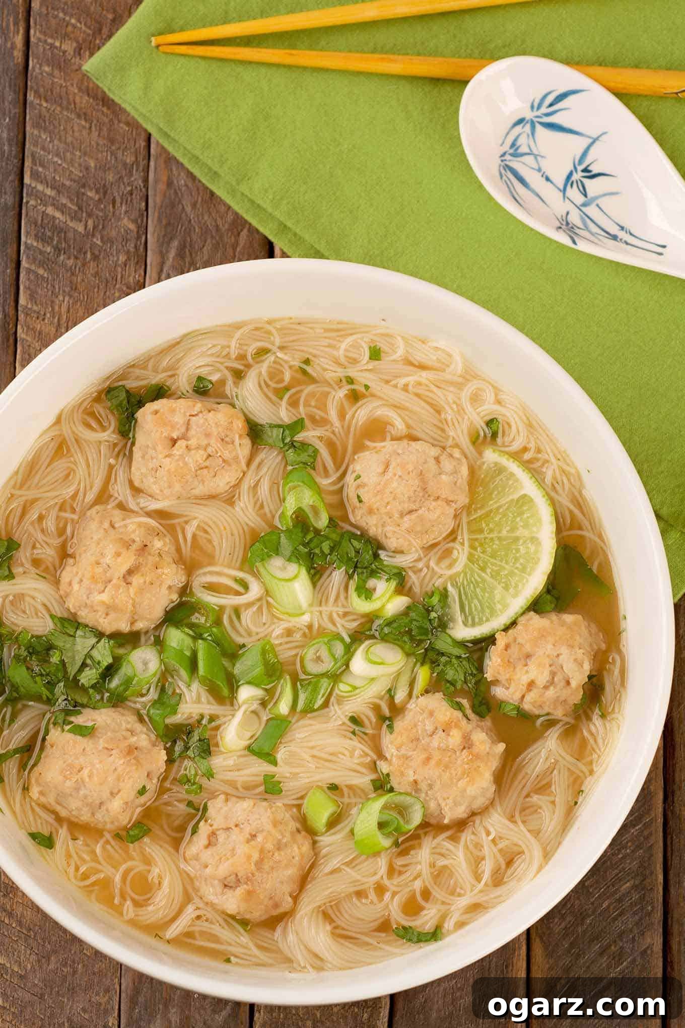Vietnamese Bò Viên Noodle Soup 2 Aromatic Vietnamese chicken meatball noodle soup, garnished with fresh herbs and lime, ready to be enjoyed.