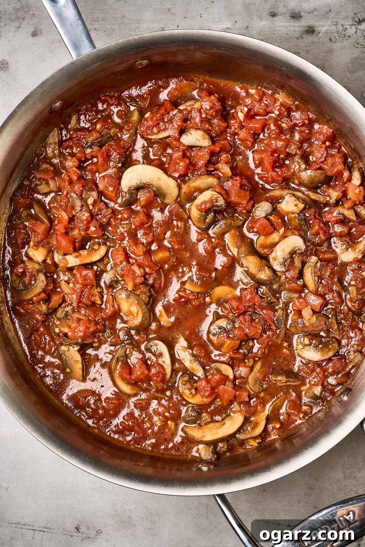 Umami Eggplant and Mushroom Pasta 4 An overhead view of a pan full of mushroom tomato sauce, ready to be combined with chunks of roasted eggplant.