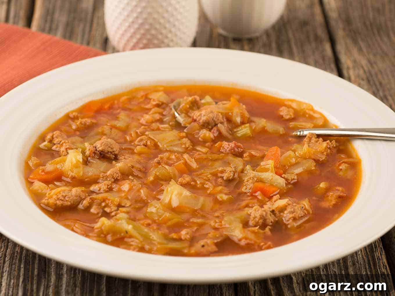 Quick & Cozy Cabbage Soup 3 A bowl of Instant Pot cabbage soup with crumbled ground turkey, smoked sausage, and cabbage in a rich tomato-based broth, garnished with fresh herbs.