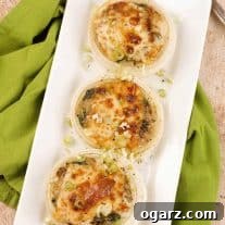 An overhead view of baked sweet onion halves filled with creamy sautéed fresh spinach and mushrooms and topped with melted cheese.