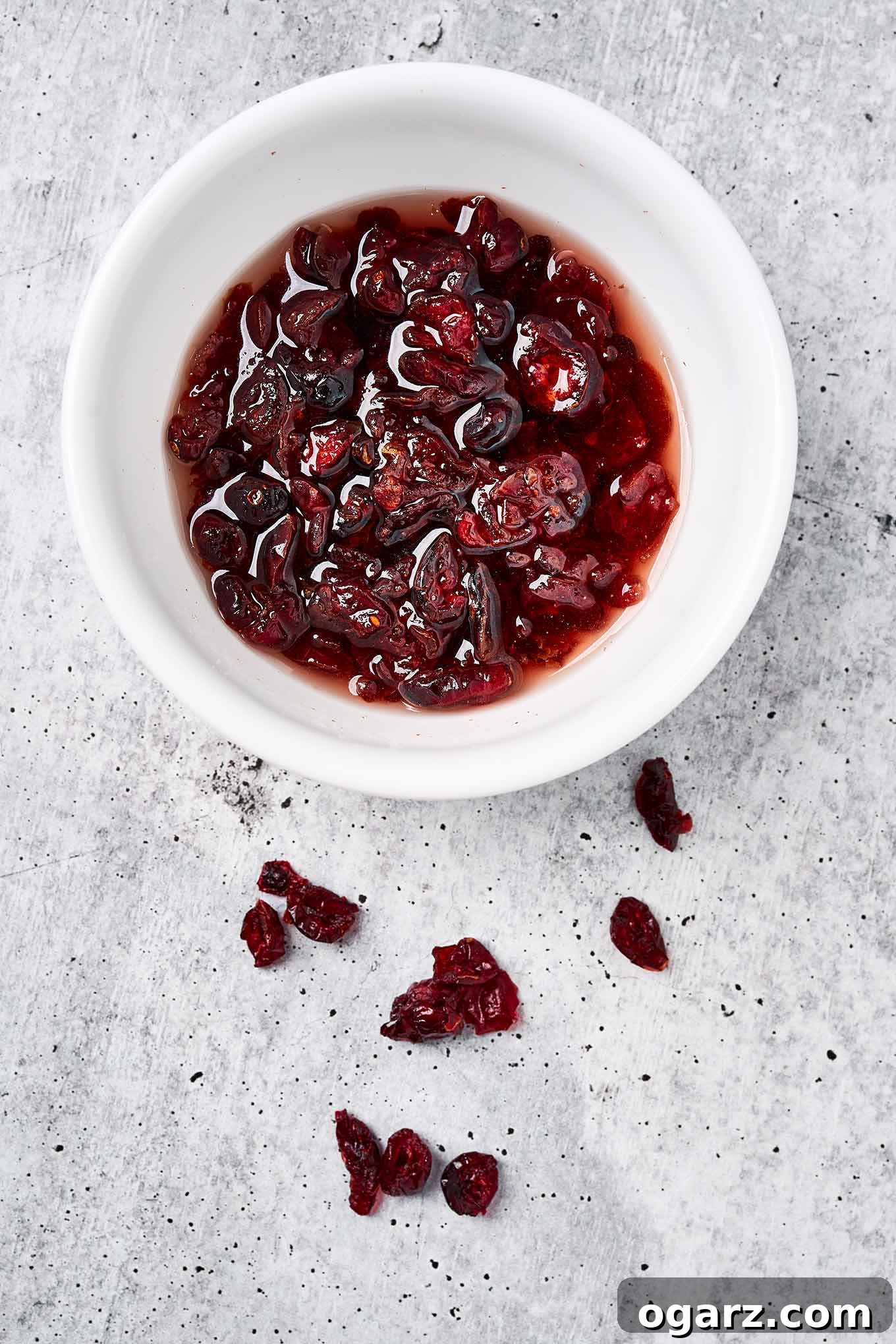 Zesty Cranberry Orange Squares 5 Dried cranberries in a bowl, soaking in hot water to plump them up for baking into cranberry bars.