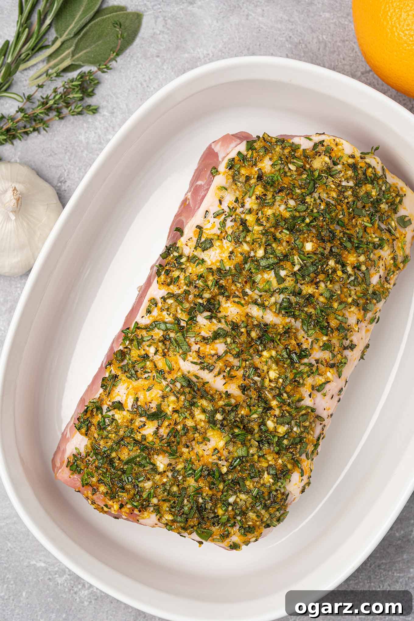 A boneless pork sirloin roast coated with garlic and herb rub and ready to go into the oven.