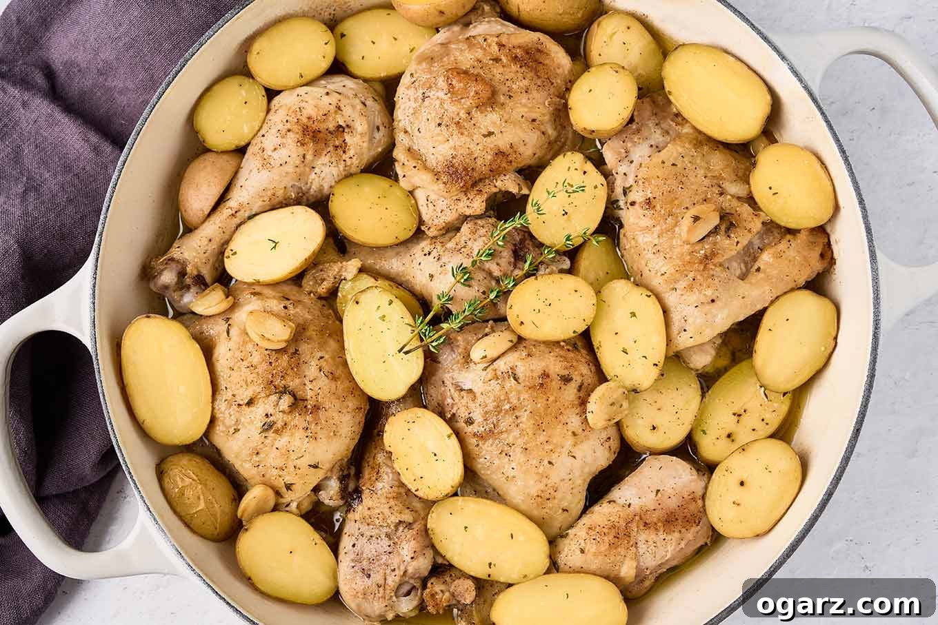 Rustic Slow-Braised Chicken and Potatoes 7 Close-up of golden-brown braised chicken legs and drumsticks, nestled among tender baby potatoes, with whole mellow garlic cloves and fresh thyme leaves, glistening with a rich pan sauce.