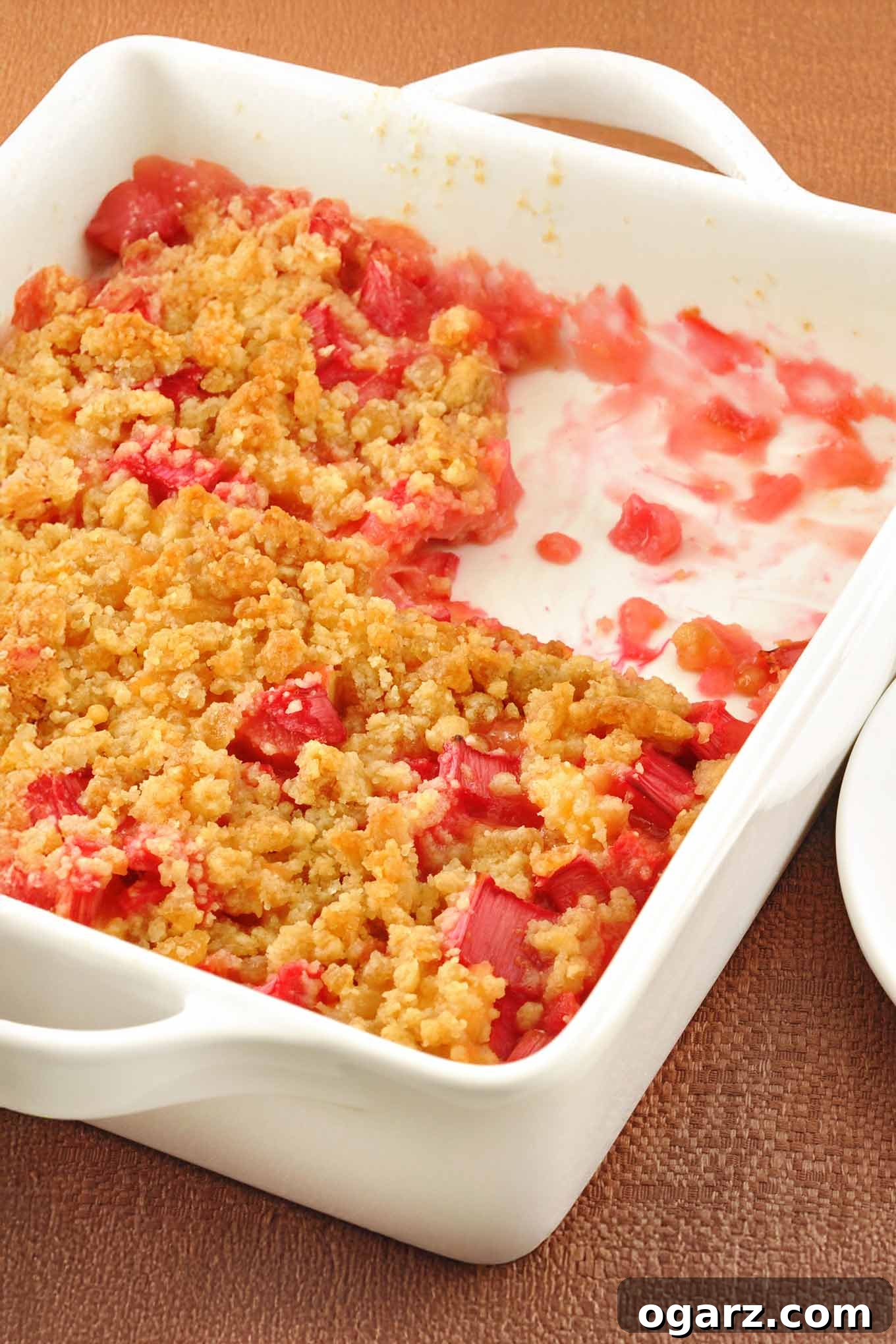 Sunshine Rhubarb Pineapple Crisp 2 Delicious Rhubarb Pineapple Crisp with a scoop removed, ready to be served, showcasing its golden-brown topping.