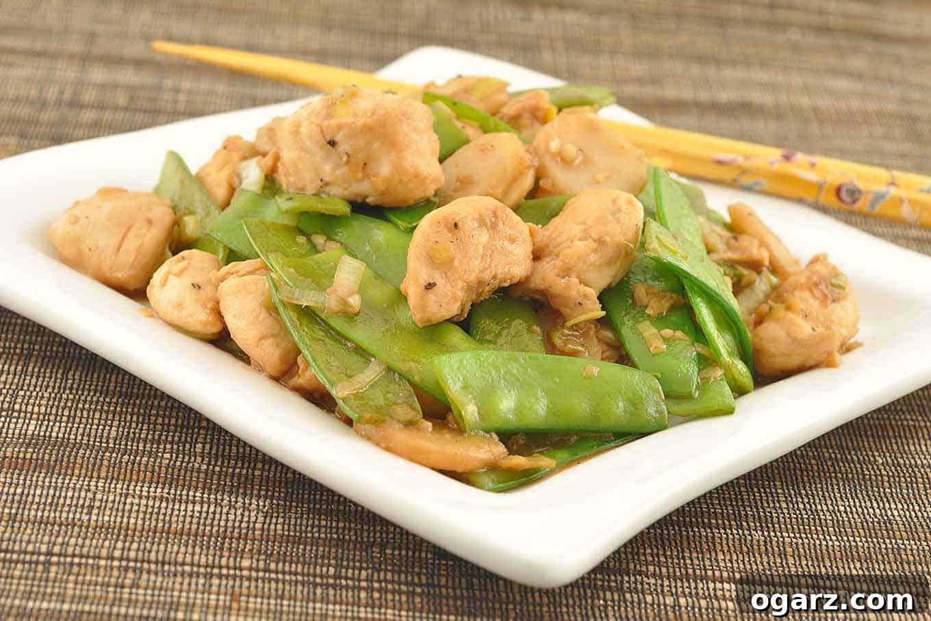 Zingy Ginger Chicken with Crunchy Snow Peas 2 Vibrant Stir-Fried Chicken with Snow Peas and Ginger served over a bed of fluffy white rice