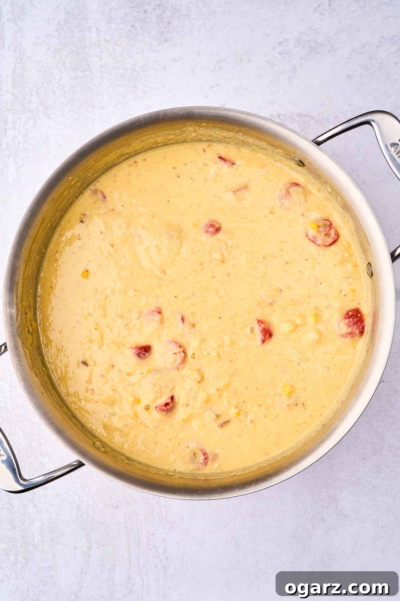Smoky Bacon & Tomato Corn Chowder 8 A soup pot brimming with rich, pureed corn chowder, generously mixed with reserved chunks of tender potatoes, vibrant fresh tomatoes, sweet corn kernels, and crispy bacon, all returned to the pan to provide appealing texture and depth of flavor.