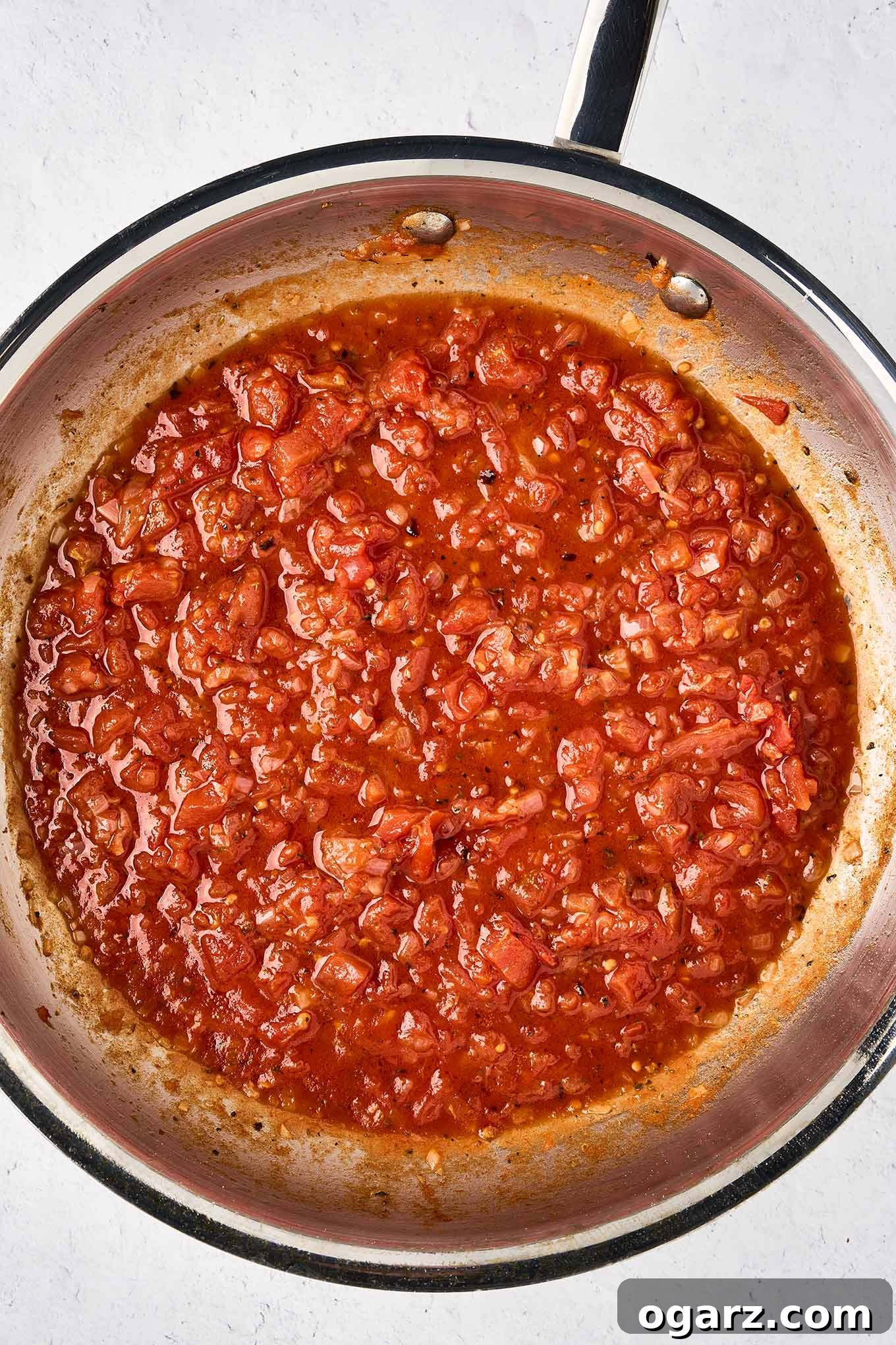 The first step in making creamy mascarpone tomato sauce; a pan filled with diced tomatoes flavored with sautéed shallots, ready for the addition of mascarpone cheese and fresh basil.