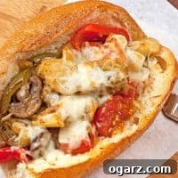 Garlic-roasted vegetable sub filled with eggplant, peppers, mushrooms, tomatoes, and melted cheese in a crusty hoagie roll.