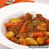 Bowl of pressure cooker beef stew with tender chunks of beef, potatoes, carrots, and rich brown gravy, garnished with thyme.
