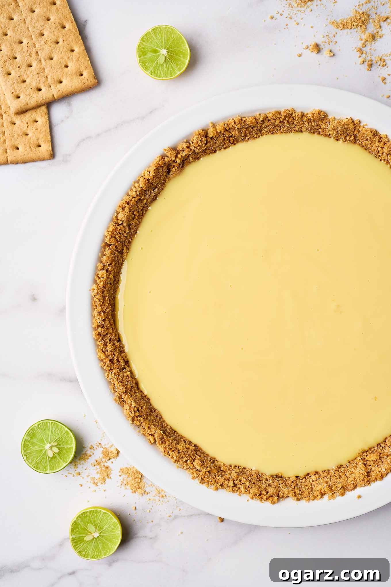 Sunshine State Key Lime Pie 5 A white pie plate with a pre-baked graham cracker crust and the key lime pie filling, ready to be baked in the oven.