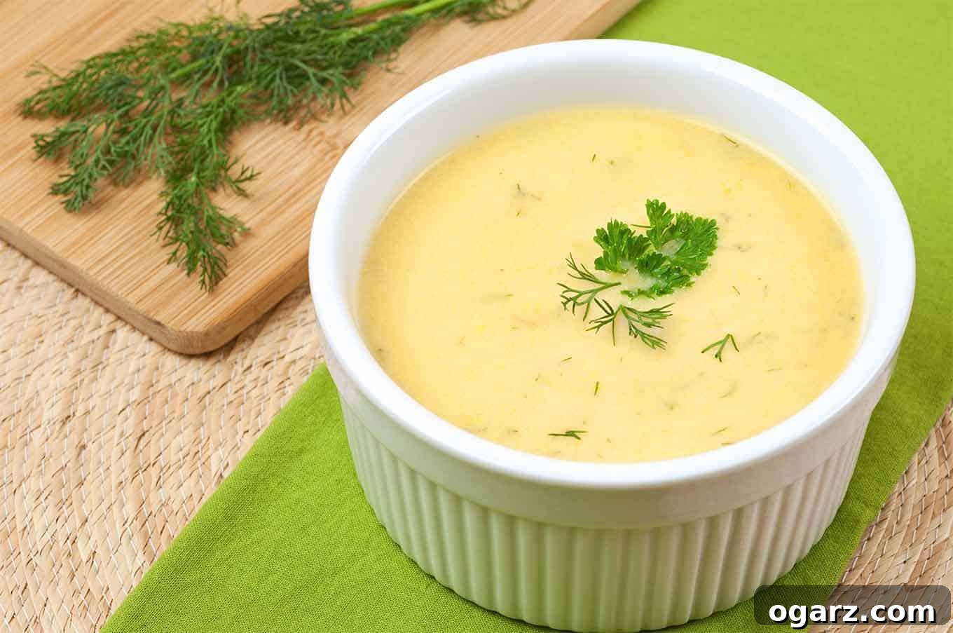 Delicious creamy summer squash soup garnished with fresh herbs, ready to be served.