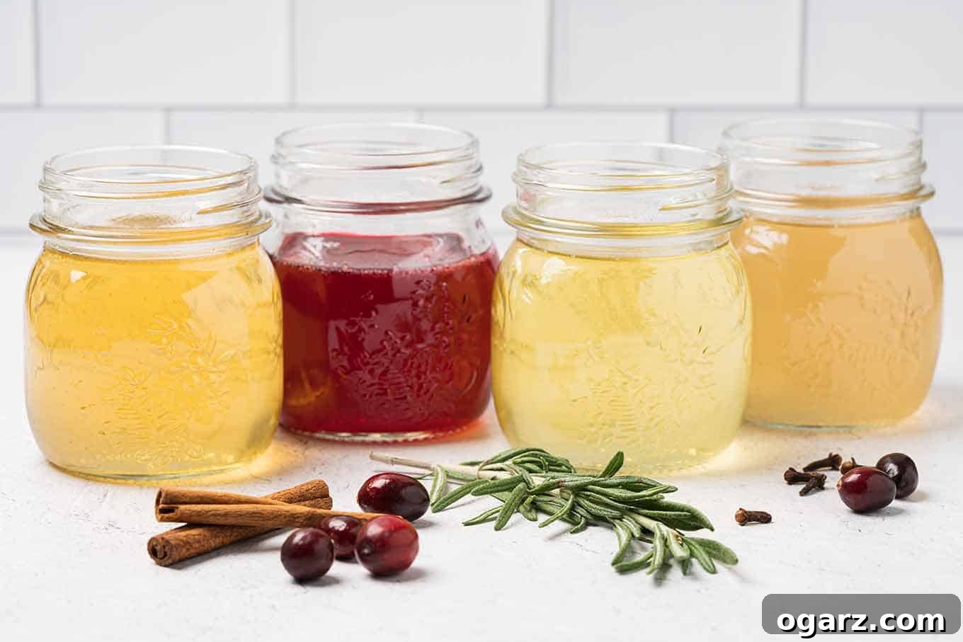 Yuletide Spiced Elixirs 2 Four glass mason jars filled with homemade holiday simple syrups: vibrant orange, rich cranberry, fresh rosemary, and warm ginger, with their respective ingredients scattered invitingly in front.