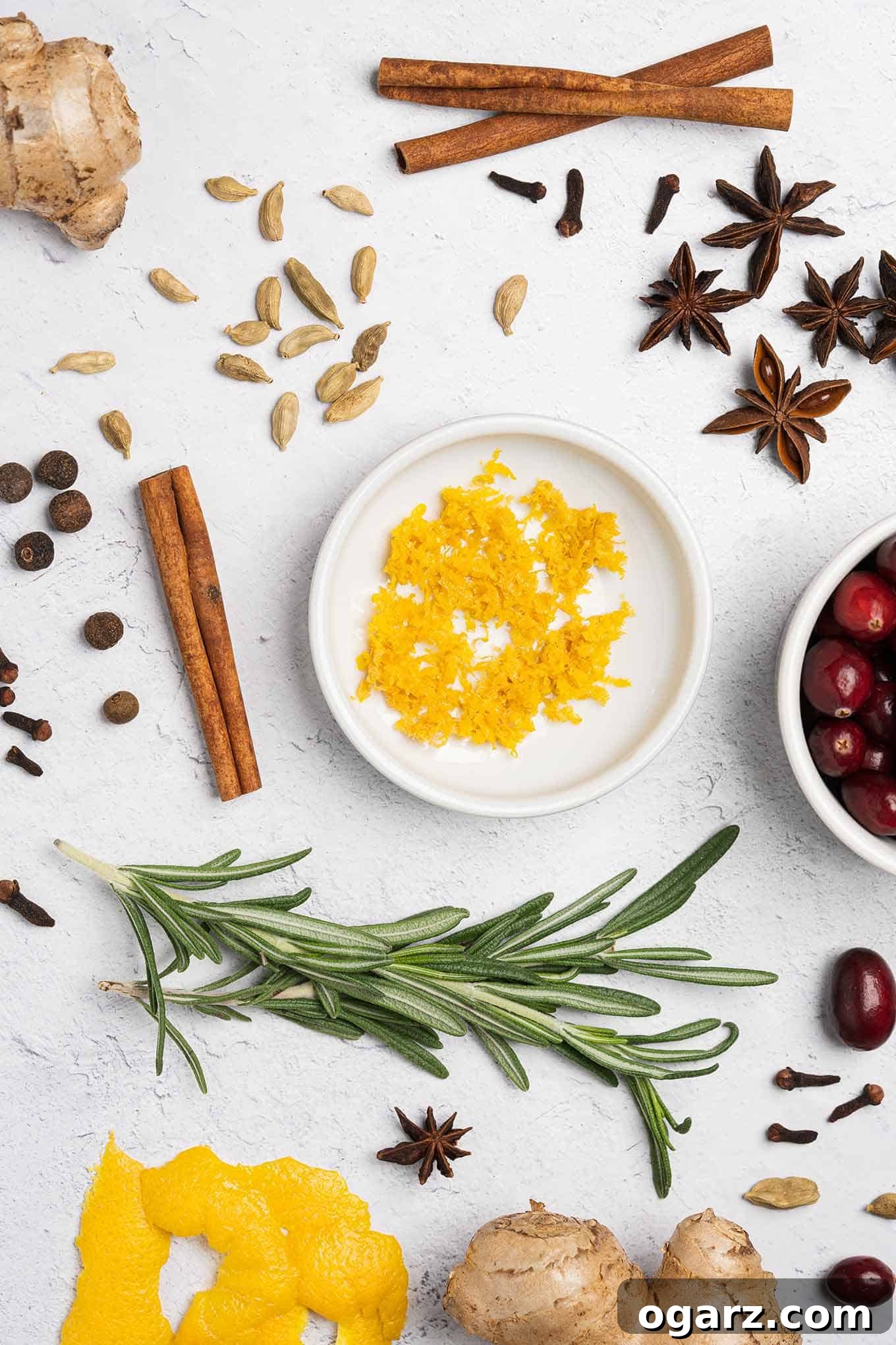 Yuletide Spiced Elixirs 3 A beautiful arrangement of fresh cranberries, fragrant rosemary sprigs, aromatic cinnamon sticks, vibrant orange zest, and various whole spices, representing the key ingredients for our holiday simple syrups.