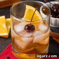 Holiday Old Fashioned cocktail garnished with an orange slice and a cherry, symbolizing festive celebration.
