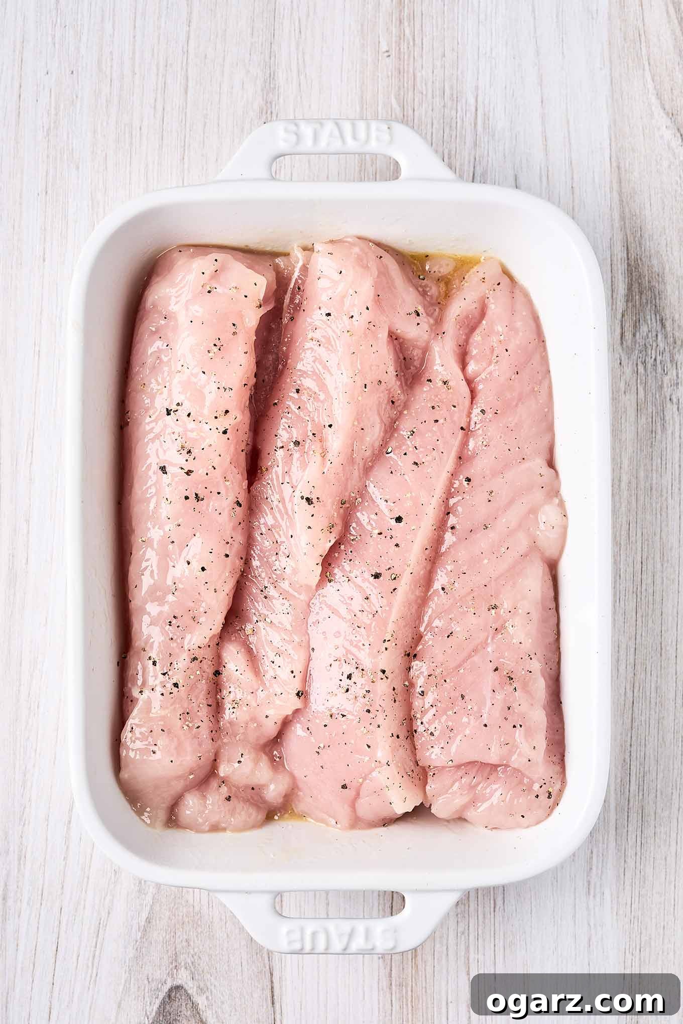 Succulent Baked Turkey Tenderloins with Savory Stuffing 5 Two raw, twelve-ounce turkey tenderloins with a pocket cut for stuffing in a white oblong baking dish.