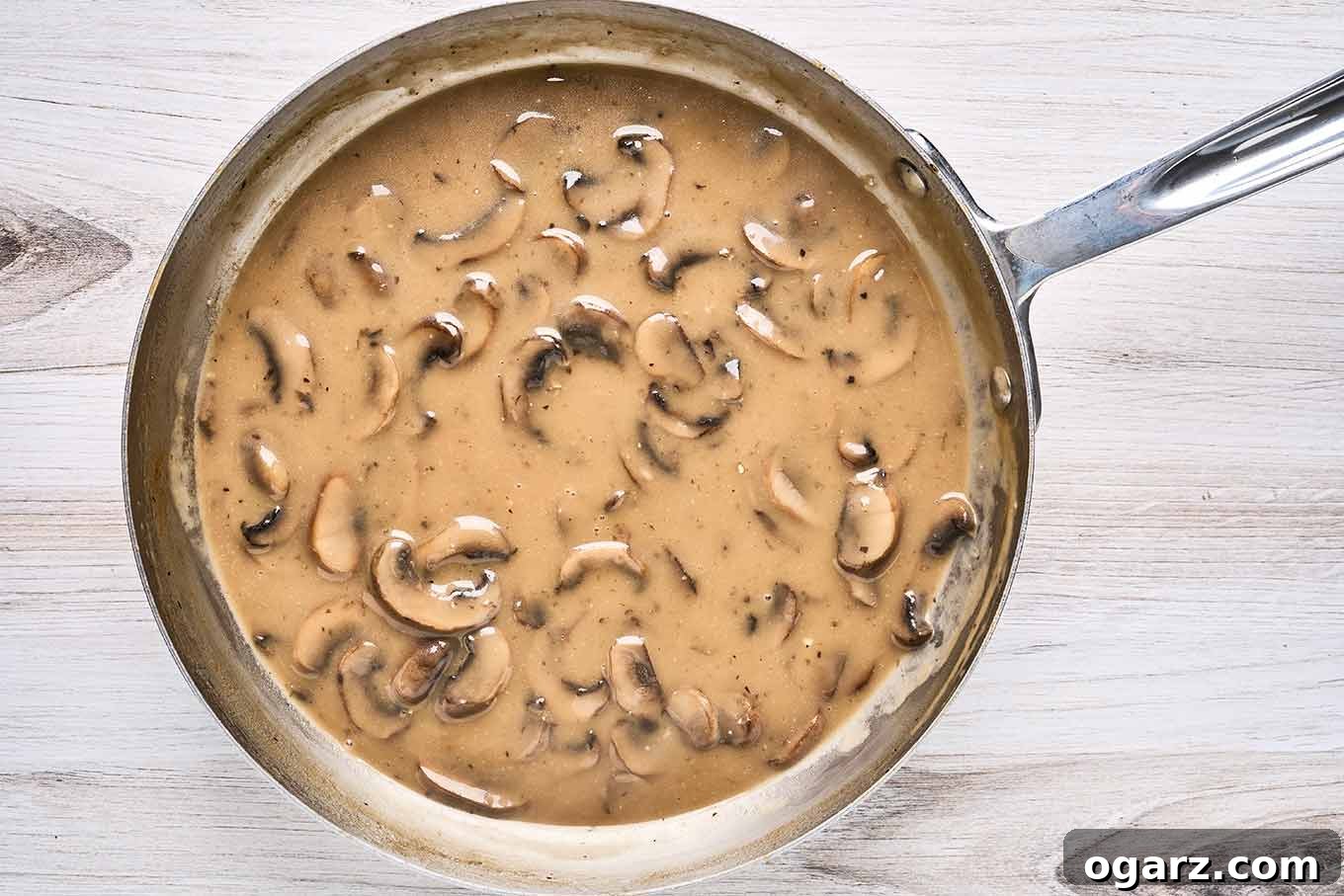 Succulent Baked Turkey Tenderloins with Savory Stuffing 8 A stainless steel saucepan filled with creamy fresh mushroom gravy.
