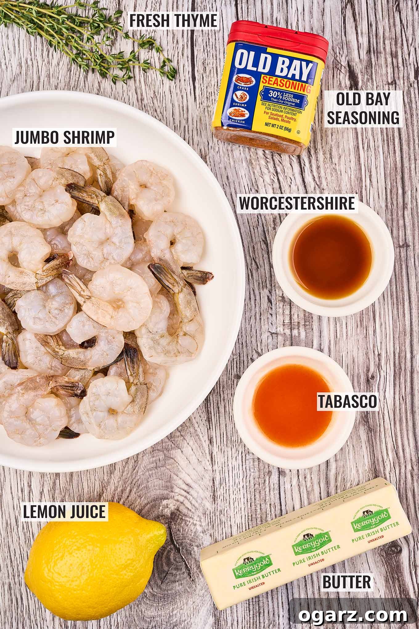 Zesty Old Bay Skillet Shrimp 3 Labeled ingredients for shrimp sauté on a grey wood background. Raw shrimp, lemon, butter, Worcestershire, Tabasco sauces, Old Bay seasoning, and thyme.