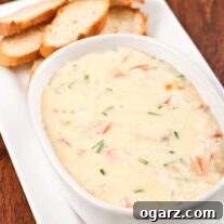 Smoked fish and Dubliner cheese dip in a serving bowl alongside toasted baguette rounds.