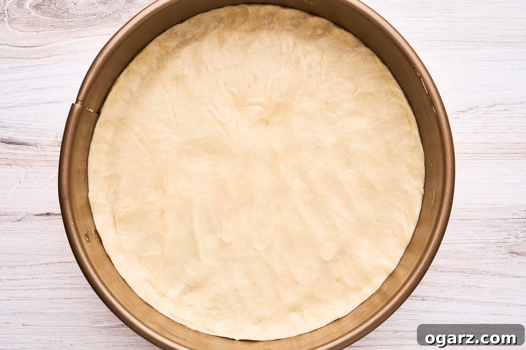 A pre-baked pie crust in a springform pan, ready for the ricotta pie filling to be added.