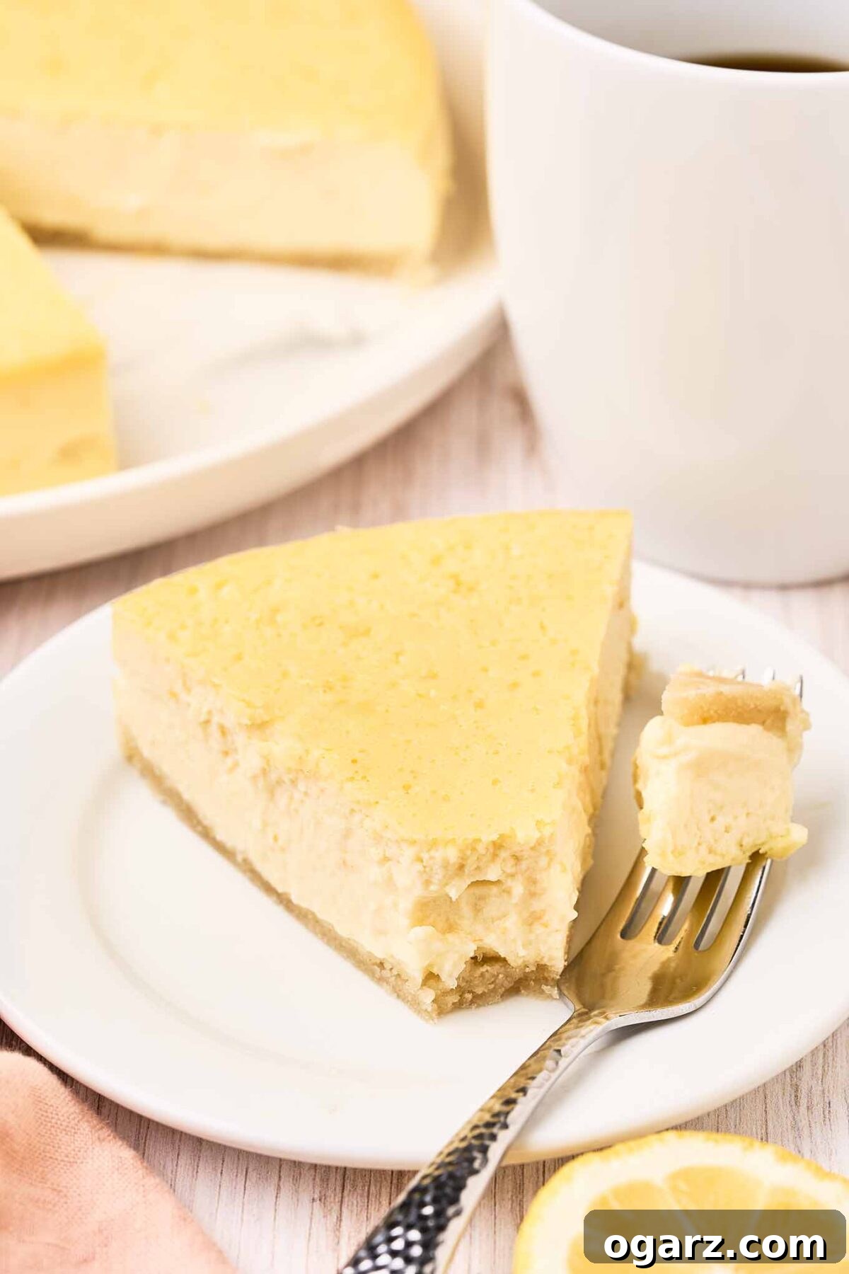 A slice of Italian ricotta pie on a plate with a bite on a fork, the remaining pie and a cup of coffee in the background.
