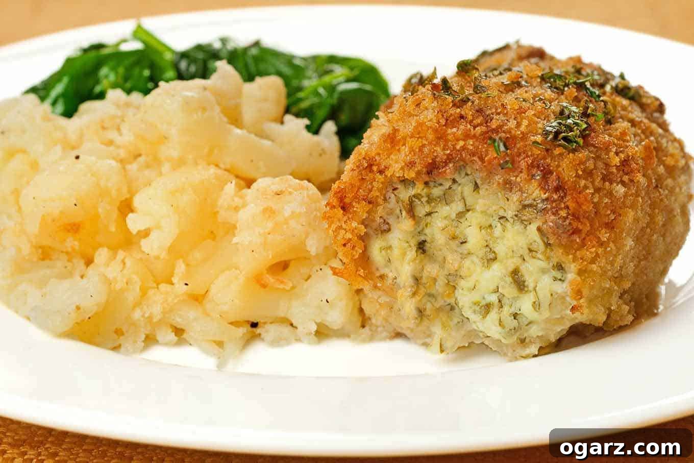 Jalapeño-cheese stuffed chicken breast with a golden crust, served with roasted cauliflower and sautéed spinach.