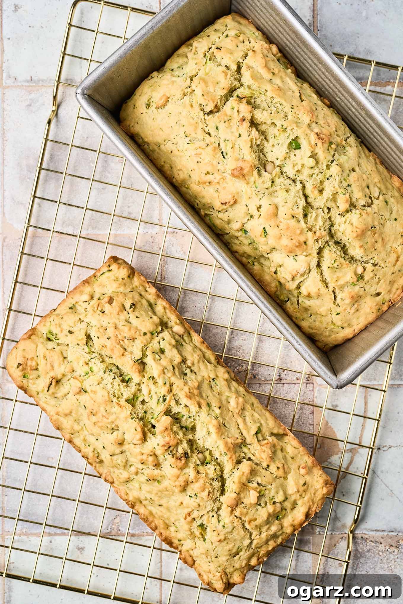 Herbed Zucchini Loaf 7 Cooling - the final step in making savory zucchini bread, one loaf directly on a cooling rack, the other still cooling in the pan.