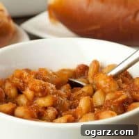 Close-up of Speedy Stovetop Baked Beans, rich with sauce and bacon bits.