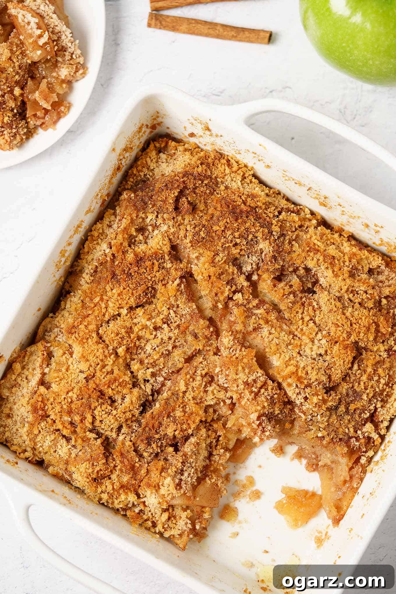 Golden Spiced Apple Bake 2 Delicious Apple Brown Betty with a golden crumb topping, served in a white baking dish with one portion removed.