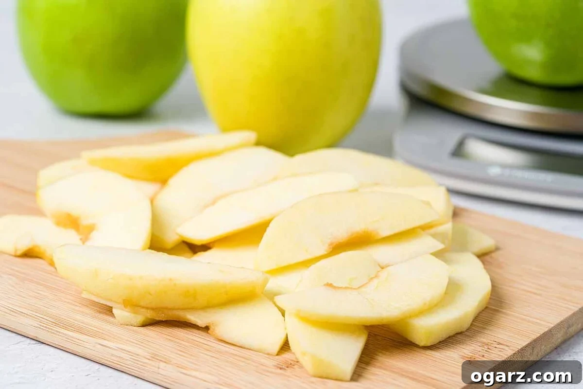 Golden Spiced Apple Bake 4 Apple brown betty preparation showing thinly sliced apples on a cutting board, with whole apples and a kitchen scale ready for baking.