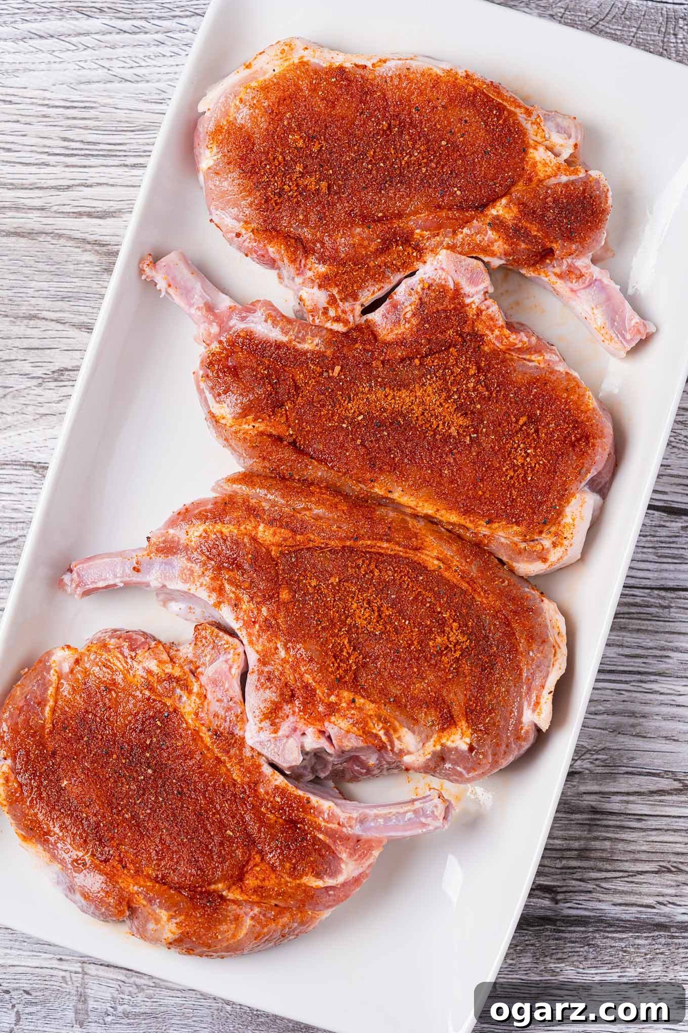 Effortless Grill Master Rub 5 Bone-in pork rib chops coated with BBQ spice rub to illustrate proper application.