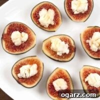 A close-up of a serving plate filled with fresh figs stuffed with creamy goat cheese, drizzled with honey and sprinkled with sea salt.