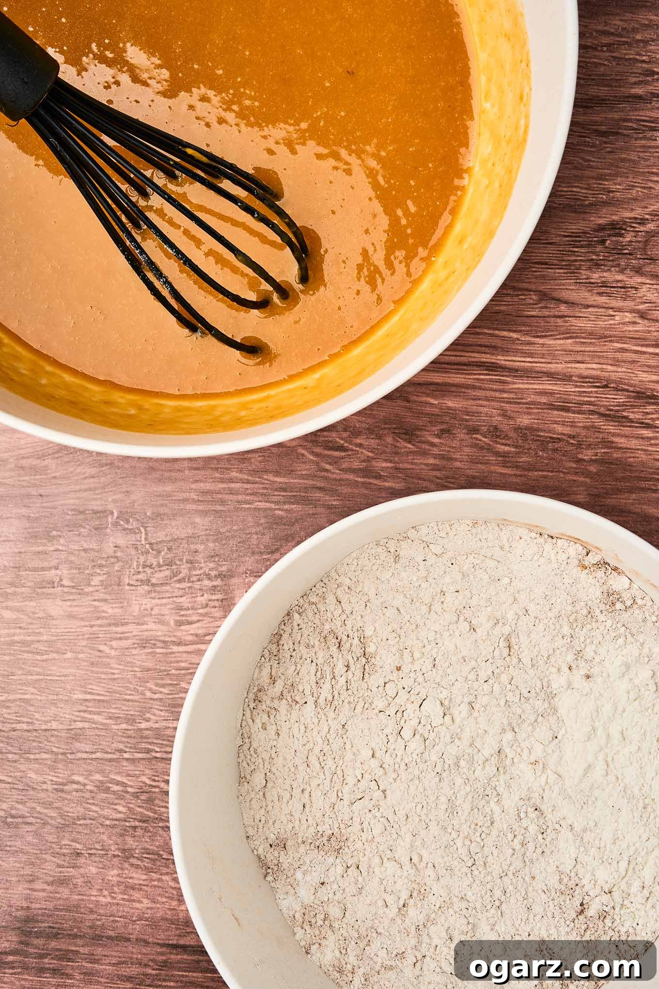 Preparing pumpkin spice muffins with two mixing bowls, wet ingredients in one, dry in the other, ready to be combined.