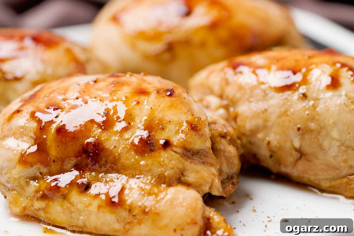 Golden Roasted Boneless Chicken Thighs 4 A close-up shot of perfectly roasted boneless chicken thighs, fresh from the oven, showcasing the bubbling, glossy balsamic and honey glaze. The edges are beautifully caramelized, highlighting the savory and sweet flavors.